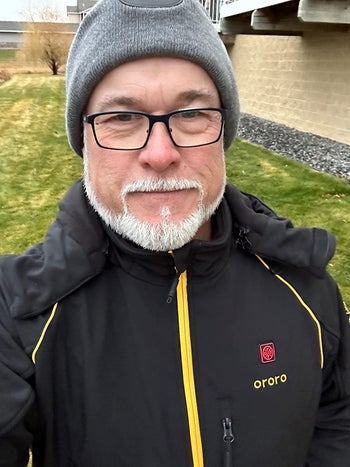 a reviewer wearing the black coat with yellow detailing