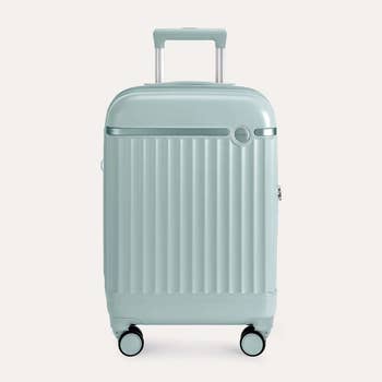 A sleek, modern   hard-shell suitcase with 4  wheels and a telescopic handle, perfect  for stylish travel