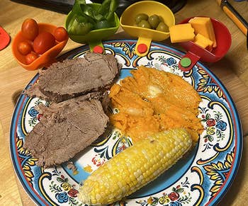Reviewer plate with small dip bowls in various colors attached and holding small snacks