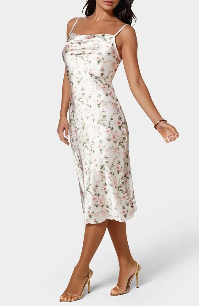 Model in a floral slip dress and sandals, posing for a shopping article