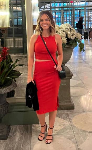reviewer in a red sleeveless knee-length skirt and tnak combo 