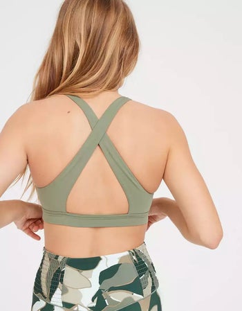 back of a model wearing the green cross-back sports bra