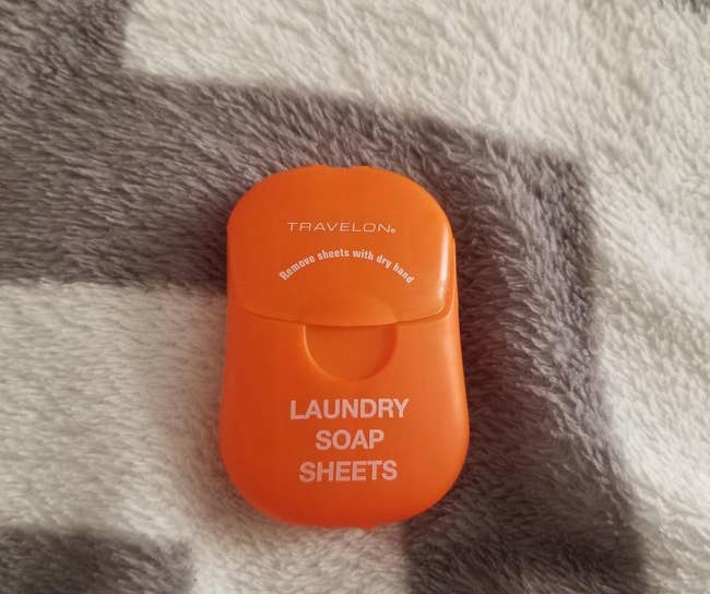 reviewer's small orange container of laundry sheets
