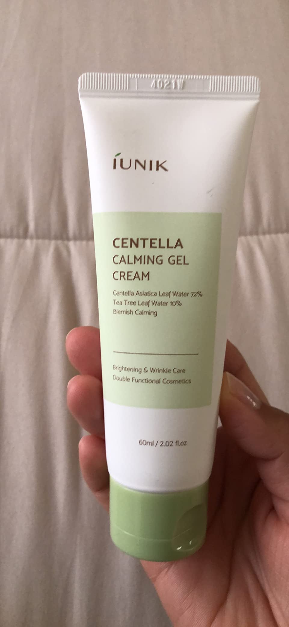 a reviewer holding a tube of calming cream