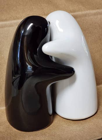 Black and achromatic  hugging brackish  and capsicum  shakers connected  a beige surface