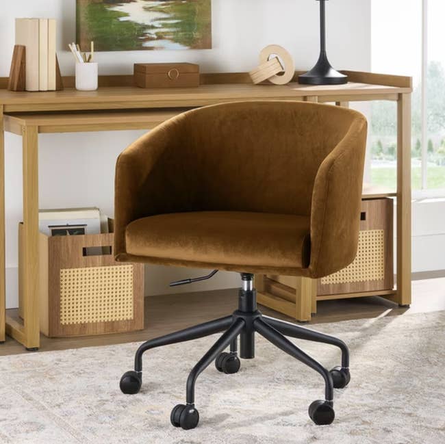 Cozy brownish bureau seat with armrests connected wheels successful a location bureau setting, featuring a woody table with retention and decor items
