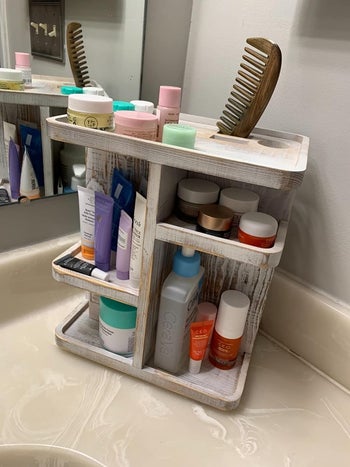 reviewer image of the cosmetic organizer on a bathroom counter filled with products