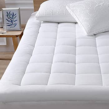 the white down mattress topper and cover on a bed