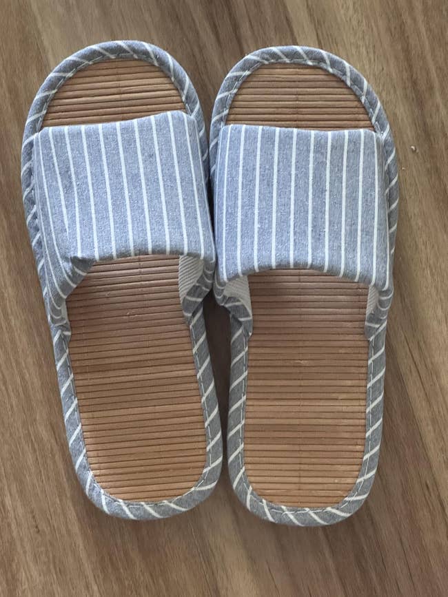 Striped cloth  slippers with a woody  sole, suitable for indoor wear, placed connected  a woody  floor