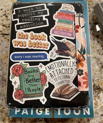 Another reviewer's Kindle case deecorated with book-themed stickers