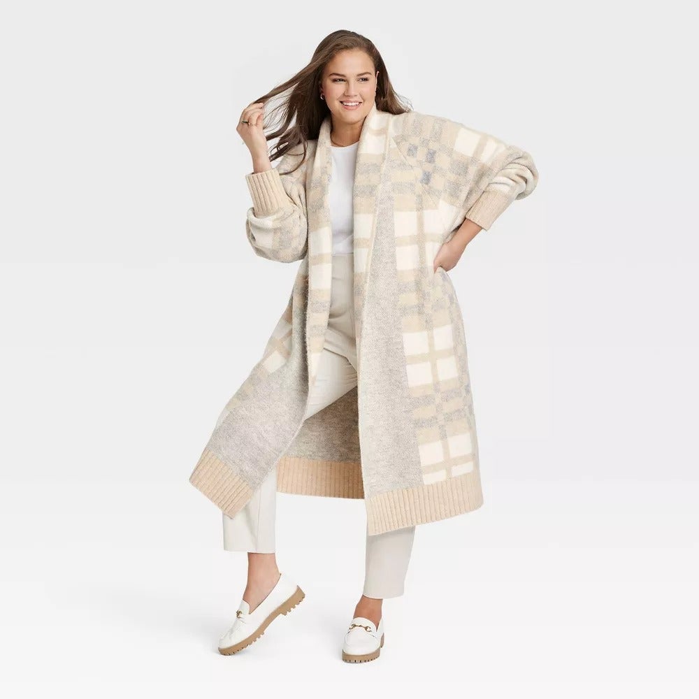a plus size model wearing the gray plaid coatigan sweater