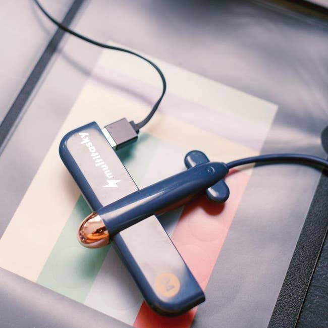 Multitasky blue airplane-shaped gadget with a USB cable attached