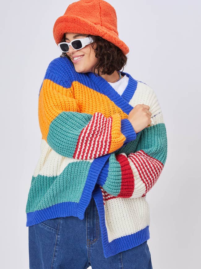 a model wearing the blue, green, red, and yellow striped sweater