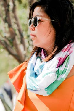a model wearing one of the travel scarves around their neck