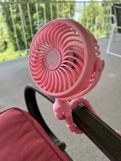 Portable fan attached to a stroller, suitable for outdoor use to keep cool while shopping or walking