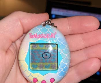 reviewer holding mermaid design tamagotchi in hand