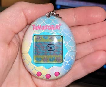 reviewer holding mermaid design tamagotchi in hand