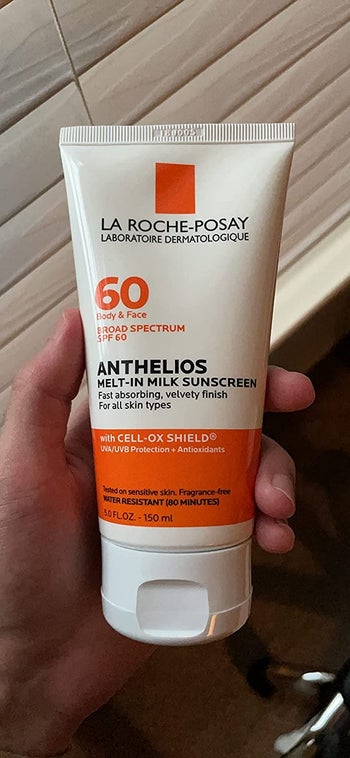 image of reviewer holding up the sunscreen