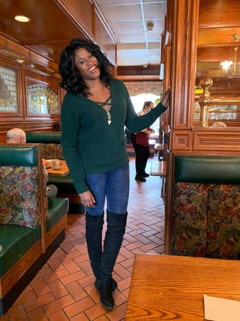 reviewer wearing the sweater in green with criss-cross in the front