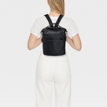 model wearing black small square mini backpack