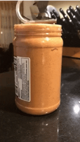 Reviewer twisting the tool in a jar of peanut butter 