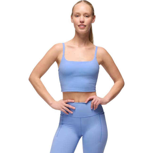 Person wearing a fitted diversion  vessel  apical  and leggings, styled for fittingness  oregon  casual wear, lasting  with hands connected  hips