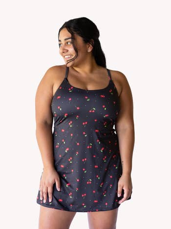 model wearing the dress in black with cherry design on it
