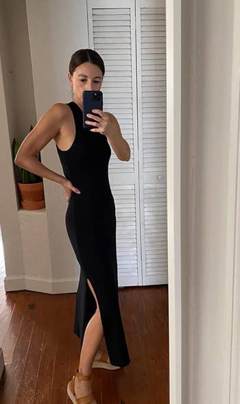 reviewer wearing the black dress with sandals