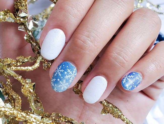 models white and blue glittery nails with snowflakes on them