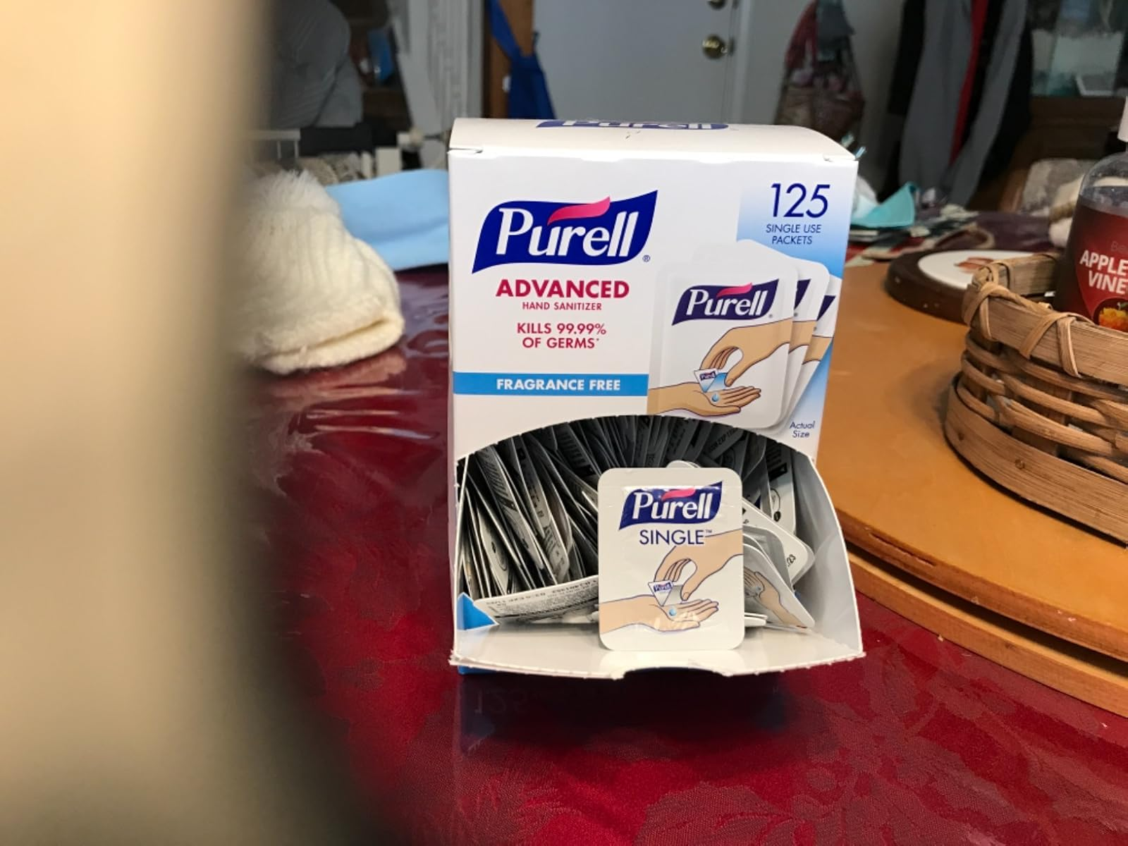 Box of Purell manus  sanitizer single-use packets connected  a table, featuring 125 packets