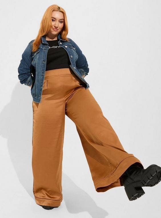 A model posing in the brown satin pants