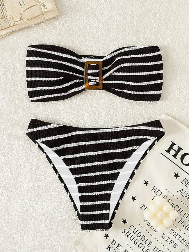 Striped bikini with a bow top and high-waisted bottom displayed on a surface