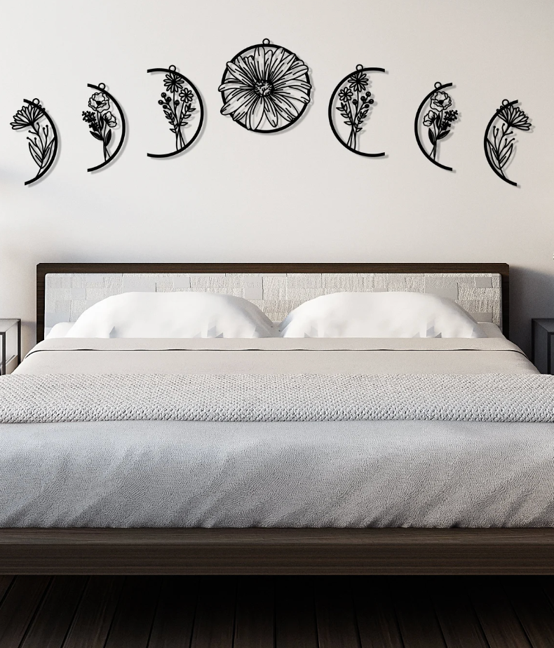 Black floral moon phase wall decals hanging above a bed