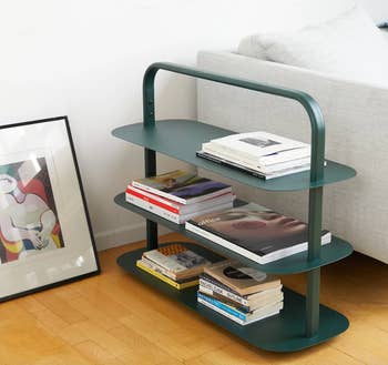green shoe rack holding various coffee table books