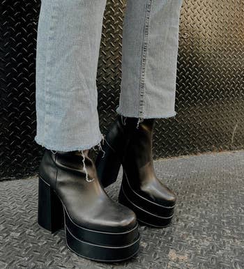 close-up of model wearing the black boots with jeans