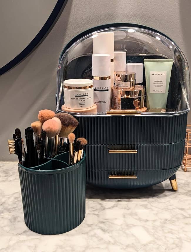 Reviewer's makeup organizer showing all the products inside and the brush container