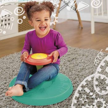 Child sitting on sit and spin stool