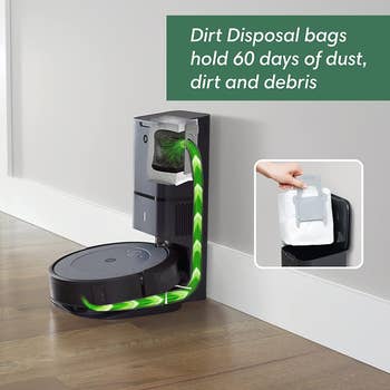 roomba docking with self emptying feature and a hand removing the bag