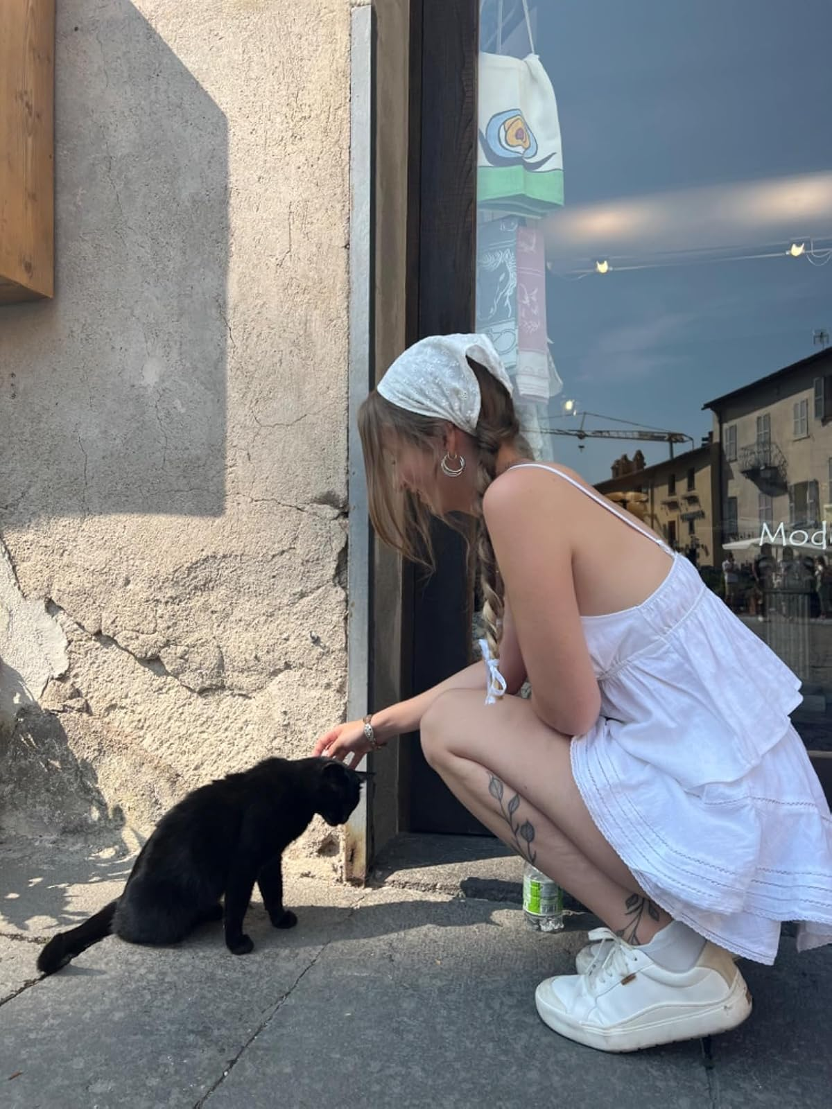reviewer petting a feline  portion    wearing the achromatic  sneakers