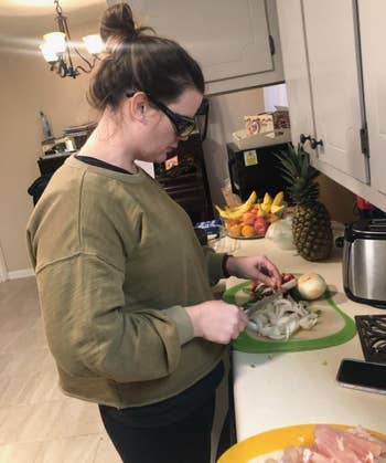 reviewer wearing the goggles while chopping onions