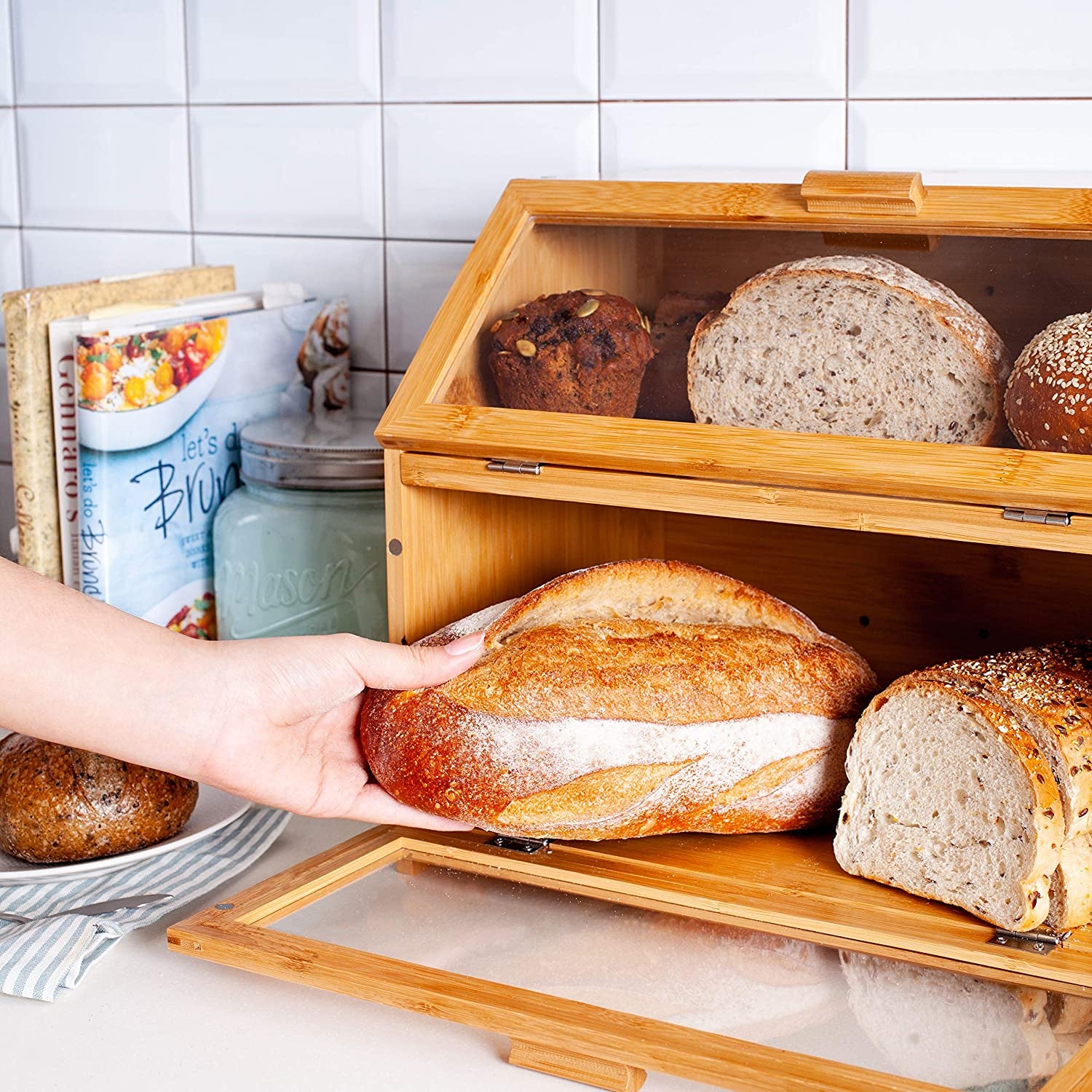 a model pulling a loaf of bread out of the bottom of the bread box
