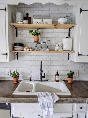 Open kitchen shelving with white tile backsplash 