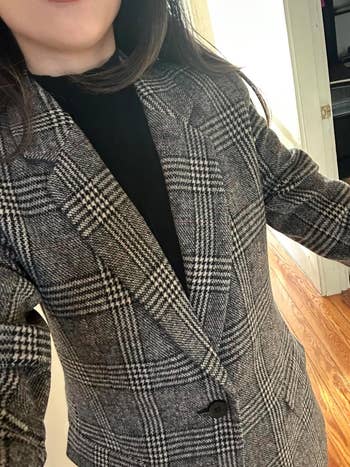 a close up of the black and white plaid blazer