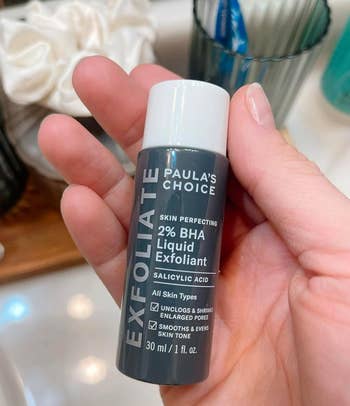 reviewer holding Paula's Choice Skin Perfecting 2% BHA Liquid Exfoliant bottle