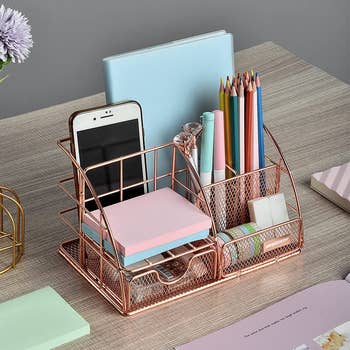 rose gold tone desk organizer with space for sticky notes, writing supplies, phone, and journals