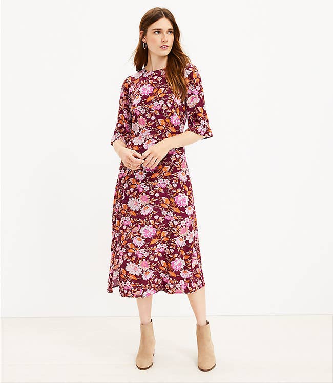 model in three quarter sleeve dark red dress with pink white and orange floral print