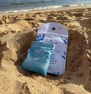 The soil  container  and its carrying pouch connected  the sand