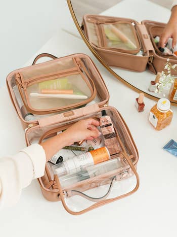 Open toiletry container connected a array with assorted skincare and constitution products, including lotions and lipsticks, successful beforehand of a mirror