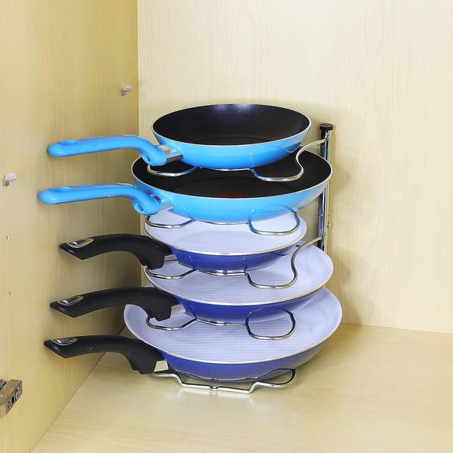 a set of five different size pans on a rack