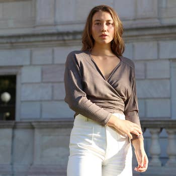 Model in a casual chic wrapped top and white pants